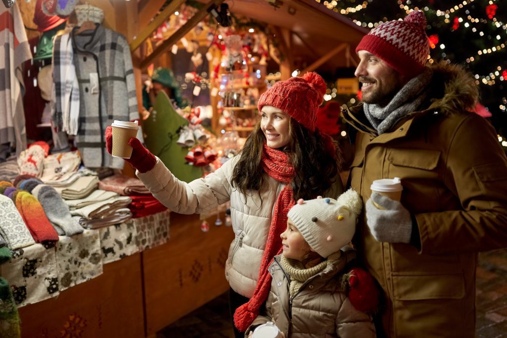 family with takeaway drinks at christmas market